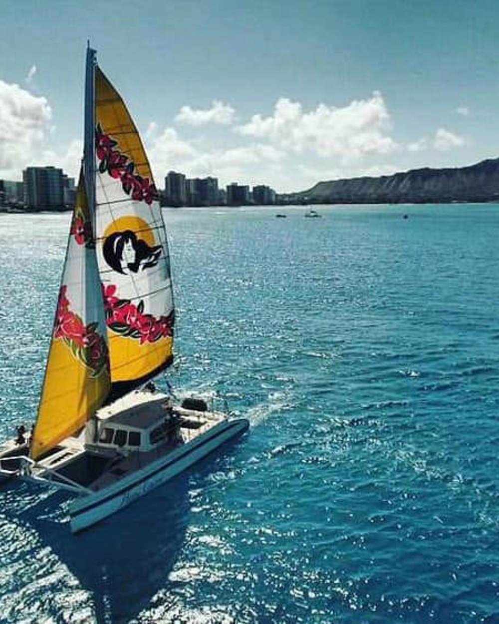 A catamaran off Waikīkī with Diamond Head behind
