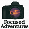 Focused Adventures Logo - Camera with lightning storm on the front of the lens and the text "Focused Adventures".