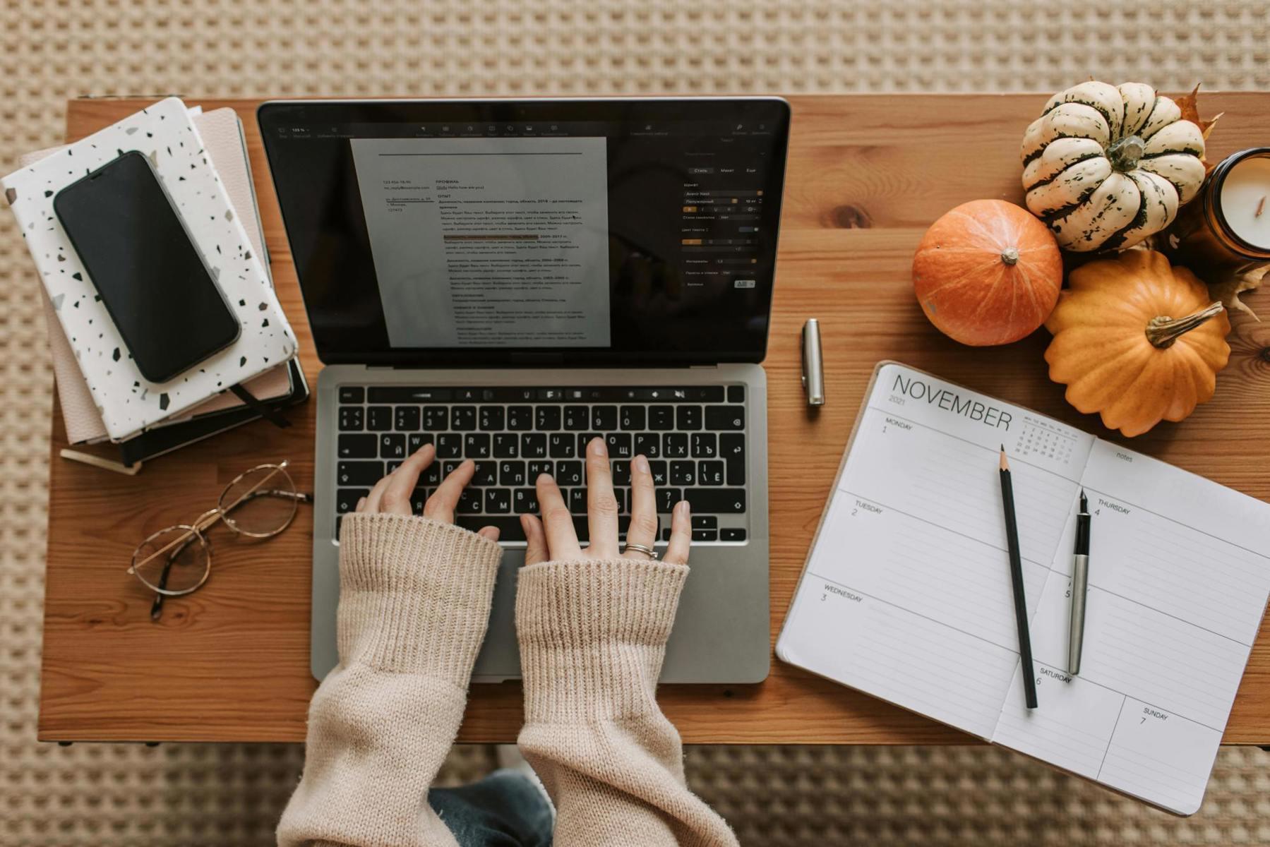 Laptop, notebook, and travel materials arranged on a cozy home planning workspace